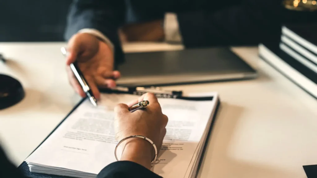 Lawyer reviewing and signing legal documents during client consultation