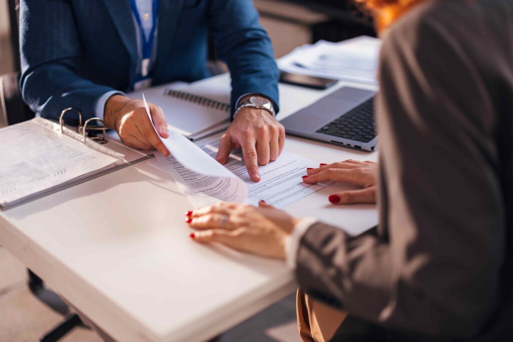 Lawyer reviewing legal documents with client at office desk during consultation