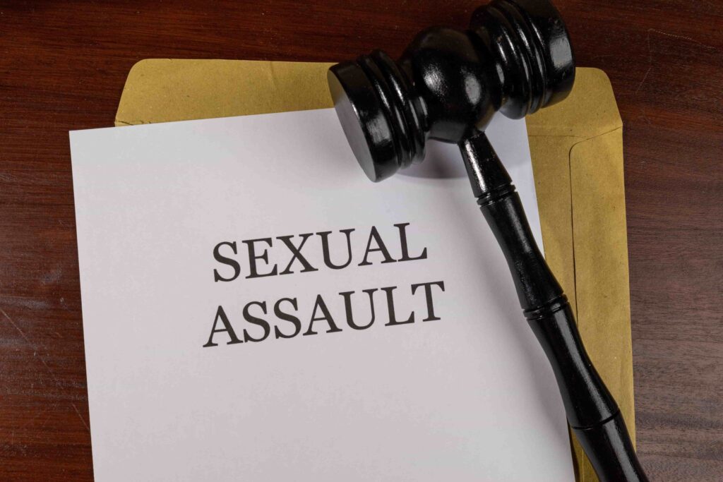 Sexual assault case file with judge’s gavel on wooden desk symbolizing legal defense and justice.