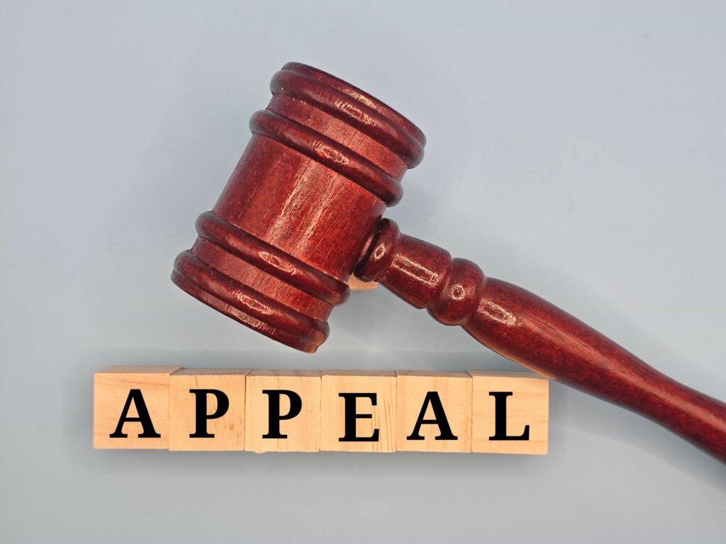 Judge’s gavel with wooden blocks spelling appeal, symbolizing legal appeals process.